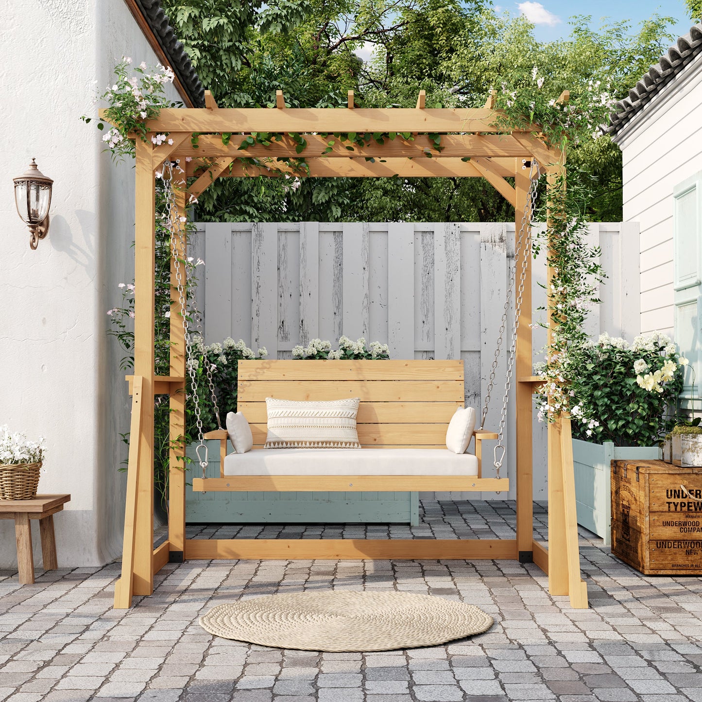 Wooden pergola with a bench on a patio area with plants and a white wall in the background