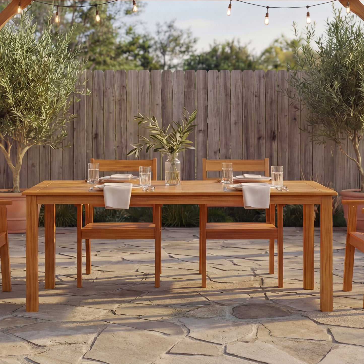 Wooden outdoor dining set with table and chairs on a stone patio