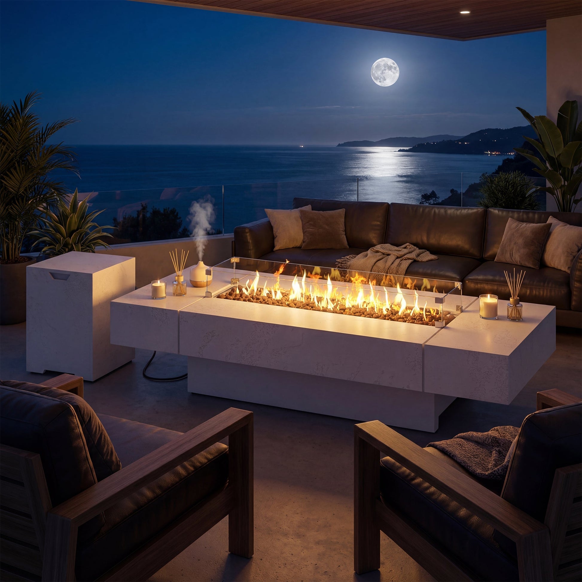 Outdoor patio with fire pit table, couches, and ocean view at night.